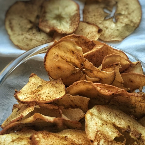 A bowl of sweet, crispy thinly sliced apple chips.
