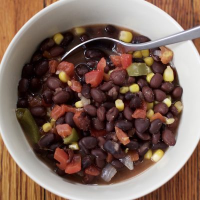 Soup bowl of black beans, corn, diced tomatoes and onions made in vegetable broth.