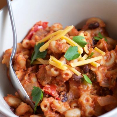 Cooked elbow macaroni mixed with peppers, onions, black, white, and kidney beans, and cheddar cheese.