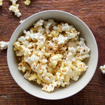 Bowl of popcorn topped with margarine and chili powder.