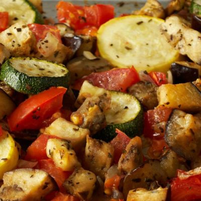 A plate of chopped eggplant, zucchini, bell peppers, onions, tomatoes and rice