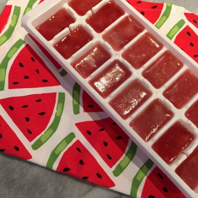 Ice tray filled with watermelon flavored water.