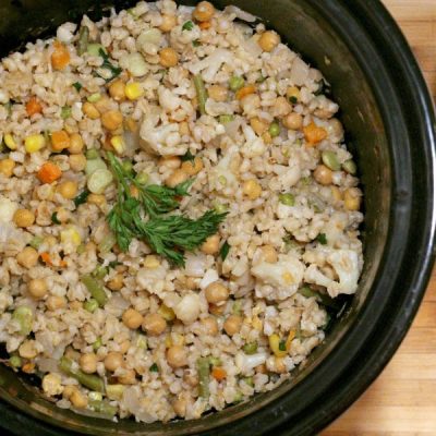 Crockpot filled with chickpeas, barley and other vegetables. Topped with fresh parsley.