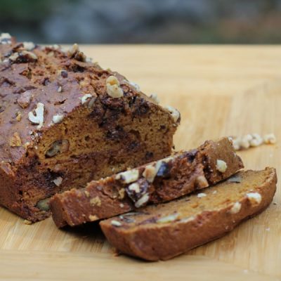 A hearty looking loaf of pumpkin bread with walnuts and chocolate chips.