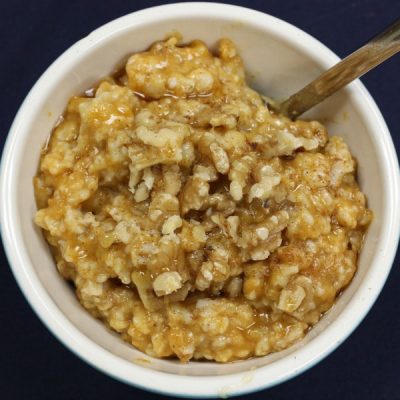 A bowl of pumpkin oatmeal with walnuts.