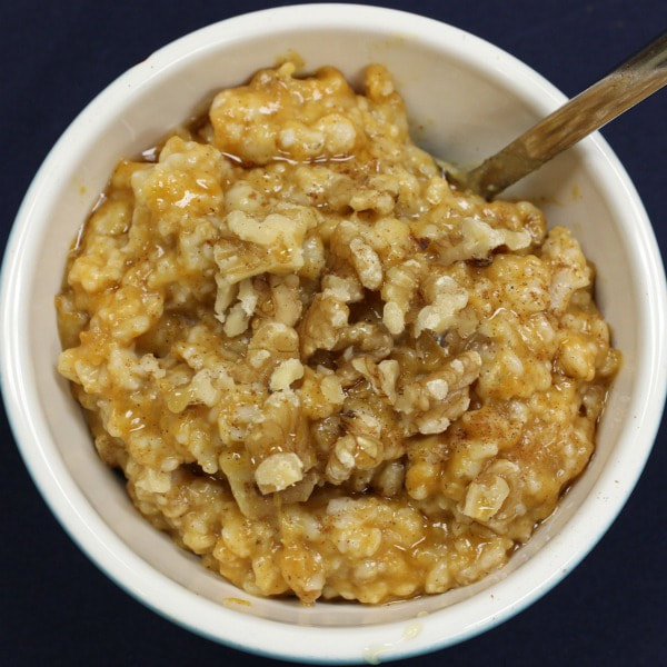 A bowl of pumpkin oatmeal with walnuts.