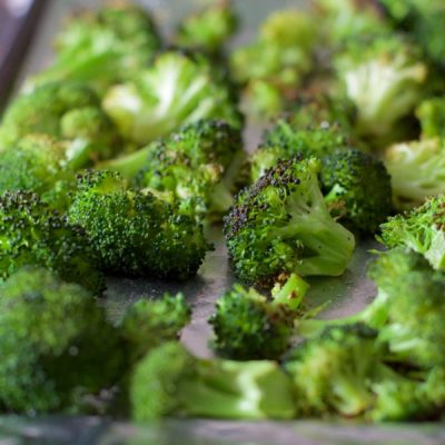 Close up of roasted broccoli on a sheet pan.
