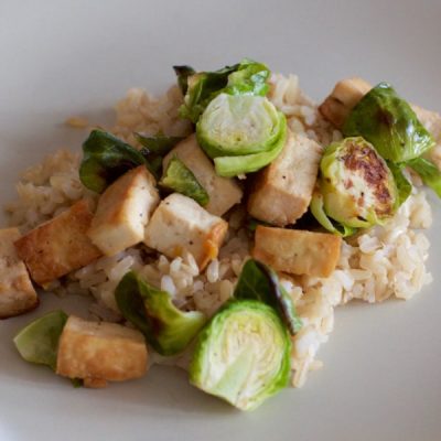 Brown rice covered in chopped Brussels sprouts and cubed tofu.