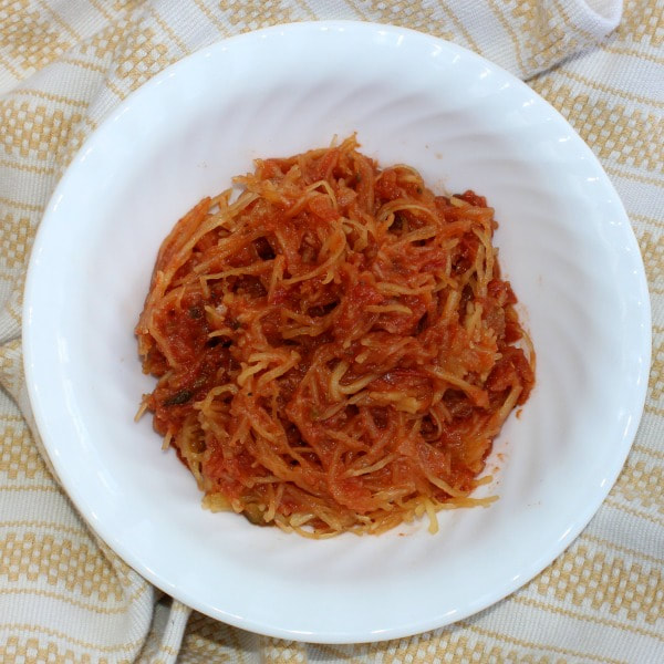 Bowl of spaghetti squash mixed with tomato sauce.