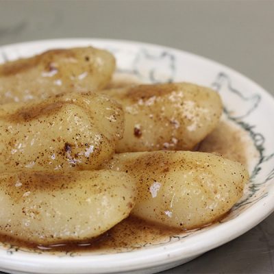 Slices of boiled pears drizzled in a seasoned liquid.