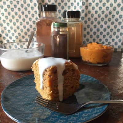 Slice of sweet potato cake with a sweet topping dripping down the sides.