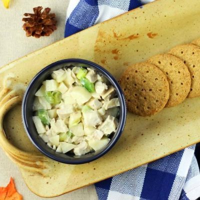 Bowl of chopped turkey, potato, celery, green peppers and onions with crackers on a plate.