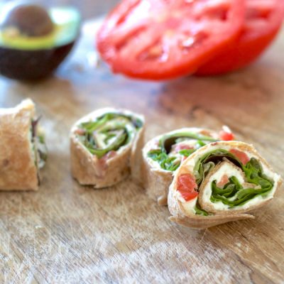 Flour tortillas rolled with tomato, spinach, and cream cheese, then cut into slices that look like pinwheels.