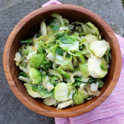 Bowl of skillet cooked brussels mixed with onion.