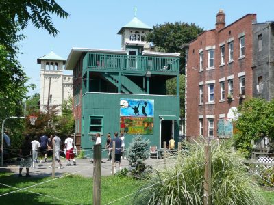 Photo of a group of people playing basketball on a community court behind the Hartford Catholic Worker house on Clarke Street in Hartford
