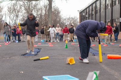 Kids competing in an outdoor obstacle course relay race.